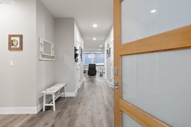 corridor featuring recessed lighting, baseboards, and light wood finished floors