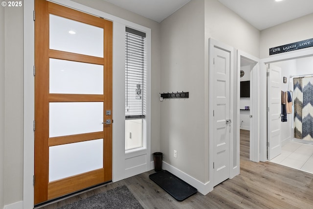 entrance foyer with light wood-style flooring and baseboards