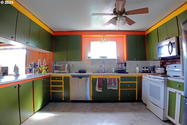 kitchen featuring ceiling fan, stainless steel appliances, sink, and green cabinets