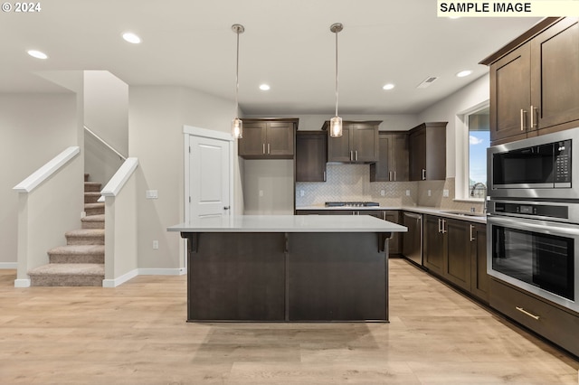 kitchen with a center island, stainless steel appliances, light hardwood / wood-style flooring, and sink