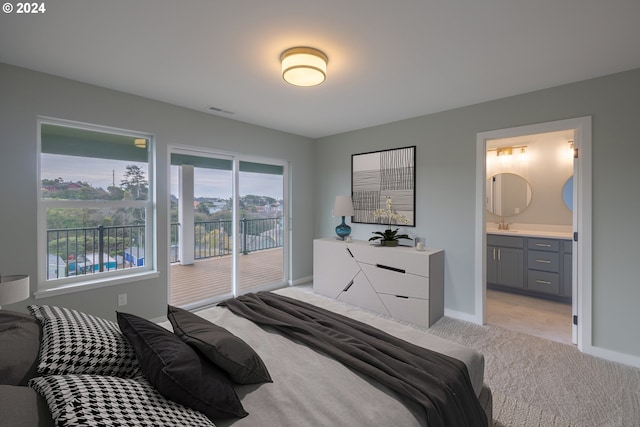 bedroom with visible vents, baseboards, connected bathroom, access to exterior, and light colored carpet