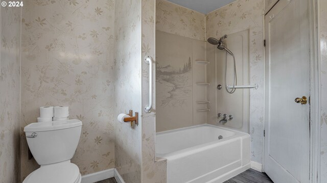 bathroom featuring wood-type flooring, shower / bathing tub combination, and toilet