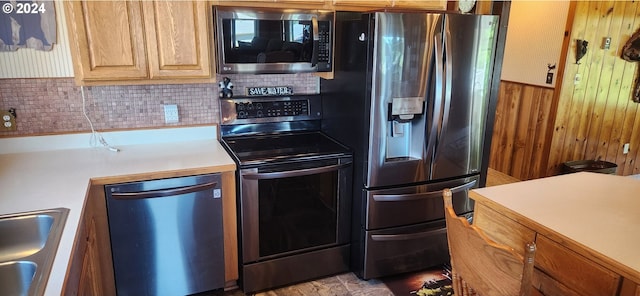 kitchen featuring wood walls, sink, and stainless steel appliances