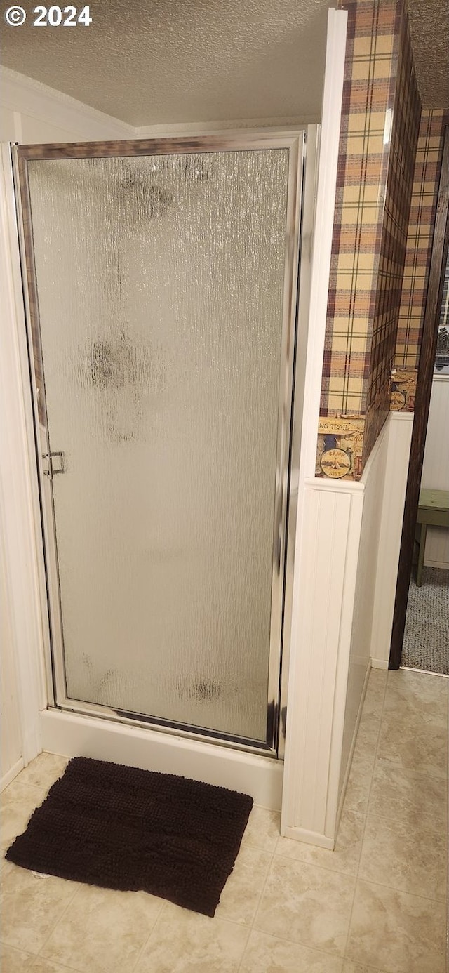 bathroom with a textured ceiling and an enclosed shower