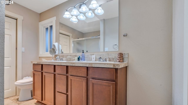 bathroom with tile patterned flooring, vanity, toilet, and a shower with door