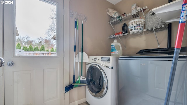 clothes washing area with independent washer and dryer and a healthy amount of sunlight