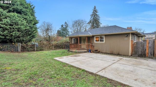 rear view of house with a patio and a lawn