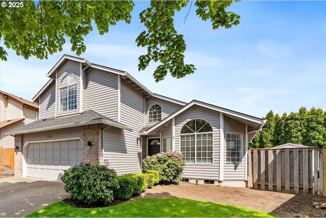 view of front of house featuring fence, an attached garage, and driveway