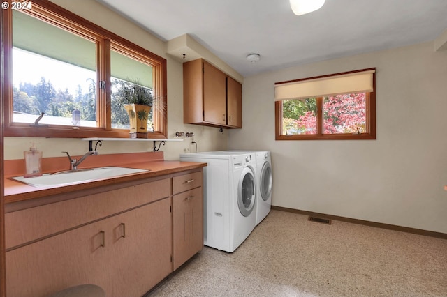 laundry room with cabinets, separate washer and dryer, and sink