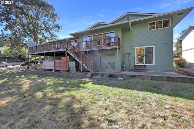 rear view of house featuring a deck, a yard, and a patio area