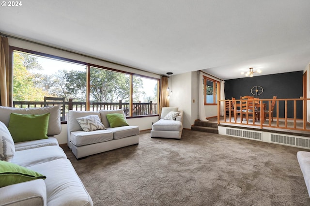 carpeted living room featuring a notable chandelier