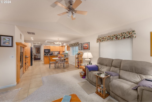 living area featuring visible vents, vaulted ceiling, light tile patterned floors, baseboards, and ceiling fan with notable chandelier