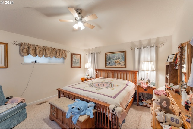 bedroom with a ceiling fan, baseboards, visible vents, and light carpet