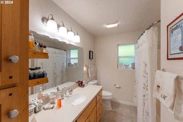 full bath featuring plenty of natural light, tile patterned floors, toilet, and vanity