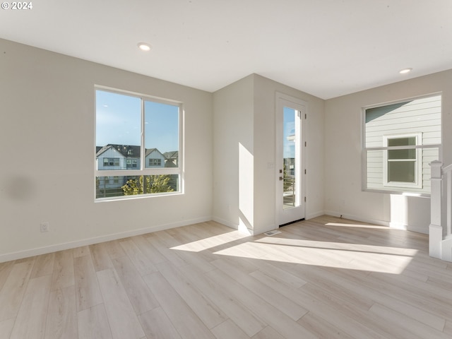 unfurnished room with baseboards, recessed lighting, and light wood-style flooring