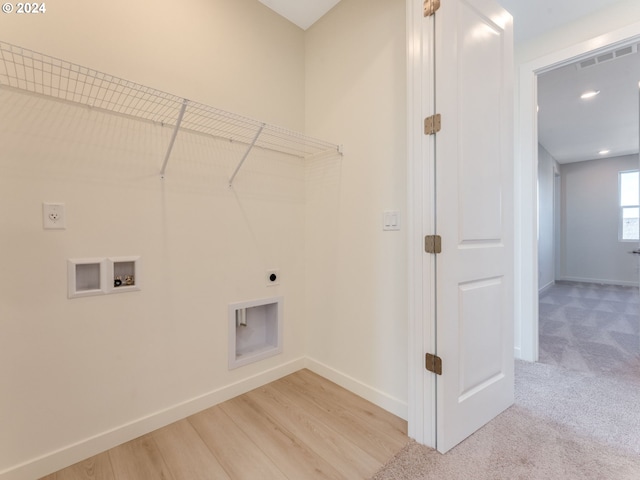 laundry area with hookup for an electric dryer, light hardwood / wood-style floors, and hookup for a washing machine