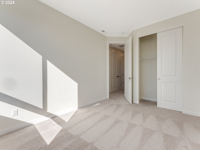 unfurnished bedroom with baseboards, carpet, a closet, and visible vents