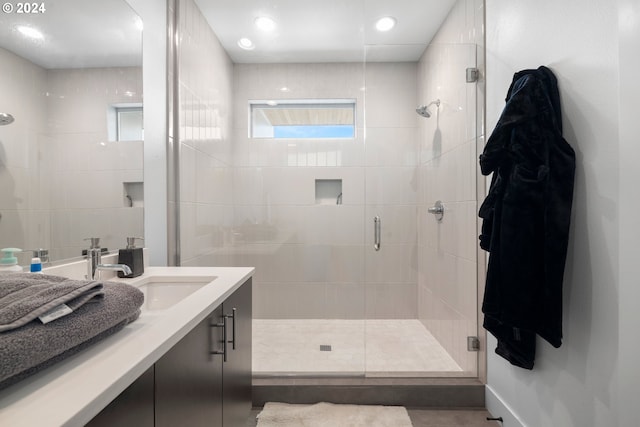 bathroom featuring vanity and a shower with door