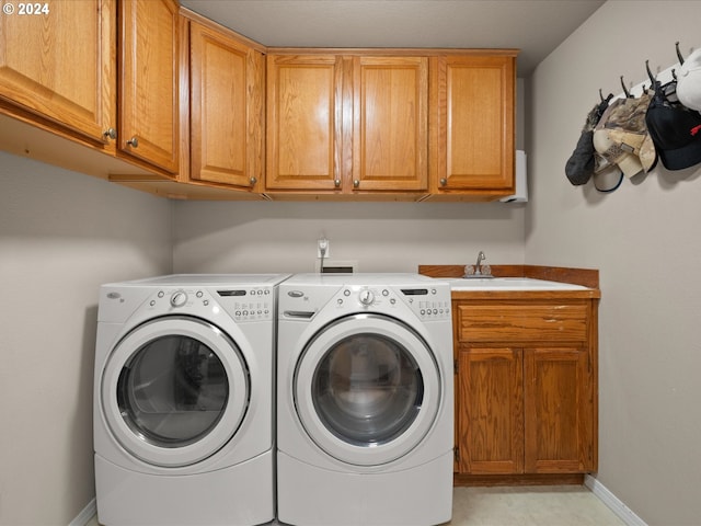 washroom with sink, washer and clothes dryer, and cabinets