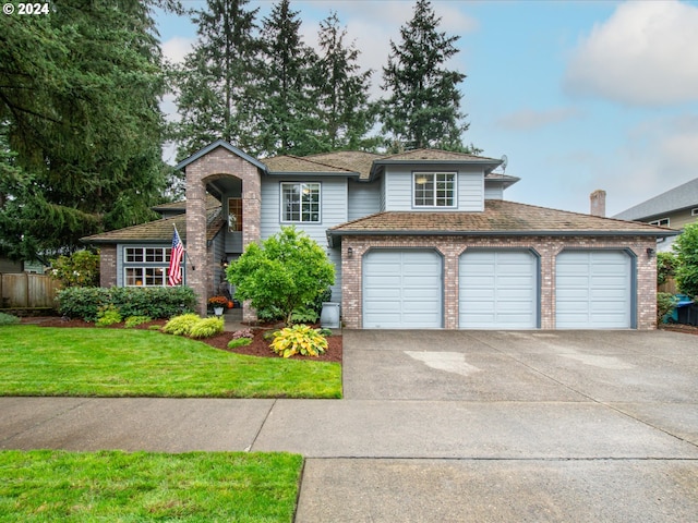 tri-level home featuring a front yard and a garage