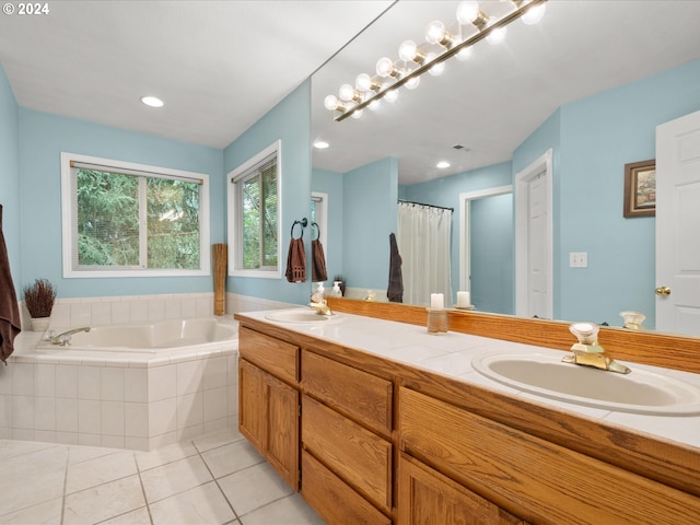 bathroom with vanity, tile patterned flooring, and tiled bath