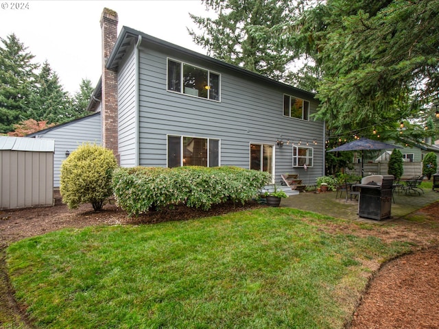 rear view of property with a patio, a shed, and a lawn