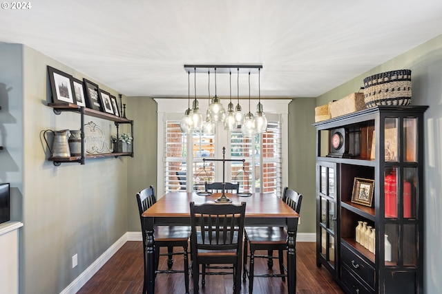 dining area featuring track lighting, dark hardwood / wood-style flooring, and a notable chandelier