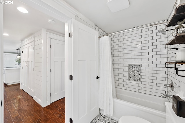 bathroom featuring hardwood / wood-style floors, toilet, and shower / tub combo with curtain