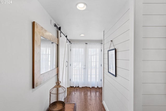 hallway featuring a barn door and hardwood / wood-style flooring