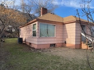 3214 W 10th St, The Dalles, OR 97058 - view of home's exterior with central air condition unit, a chimney, and a lawn