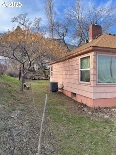 3214 W 10th St, The Dalles, OR 97058 - view of property exterior featuring a lawn, a chimney, and central AC unit