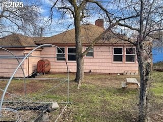 view of property exterior featuring a chimney and a lawn