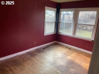 3214 W 10th St, The Dalles, OR 97058 - unfurnished room with baseboards, wood finished floors, visible vents, and a healthy amount of sunlight