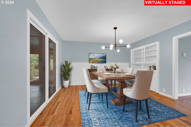 dining room with light wood-type flooring and a notable chandelier