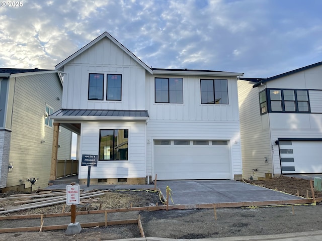 modern farmhouse with a standing seam roof, board and batten siding, concrete driveway, an attached garage, and metal roof