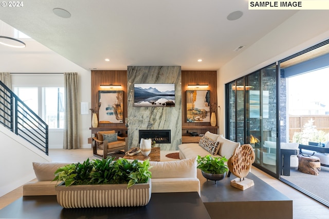 living room with plenty of natural light, a premium fireplace, and light hardwood / wood-style floors