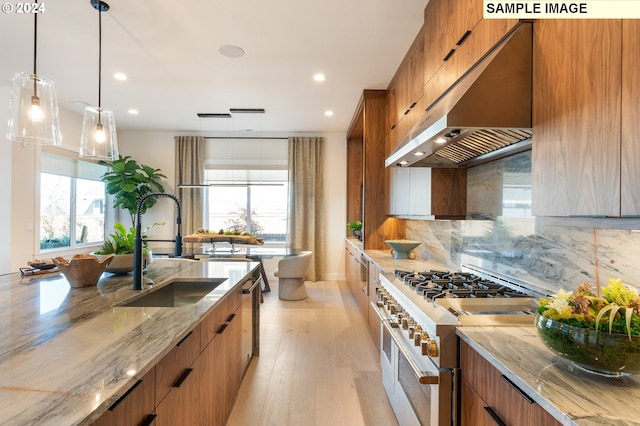 kitchen with a sink, double oven range, modern cabinets, and under cabinet range hood