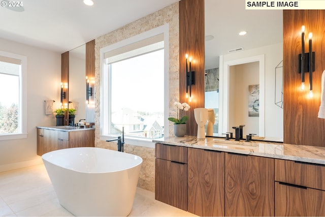 bathroom with vanity, a healthy amount of sunlight, tile patterned floors, and a tub to relax in