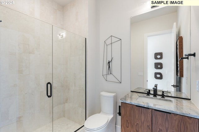 full bath featuring vanity, a shower stall, and toilet