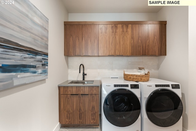 laundry room with cabinets, independent washer and dryer, and sink