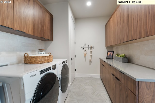 laundry area featuring separate washer and dryer and cabinets