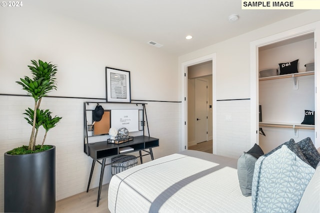 bedroom with tile walls and light wood-type flooring