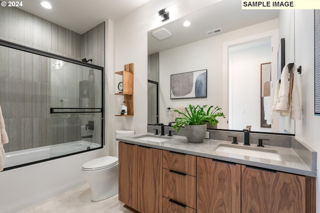 full bathroom with toilet, tile patterned floors, vanity, and bath / shower combo with glass door