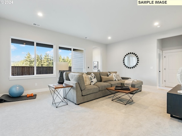 living area featuring recessed lighting, visible vents, baseboards, and light colored carpet