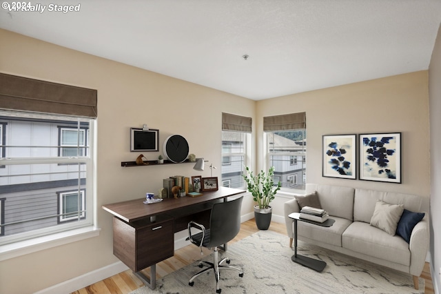 office area with plenty of natural light and light hardwood / wood-style flooring