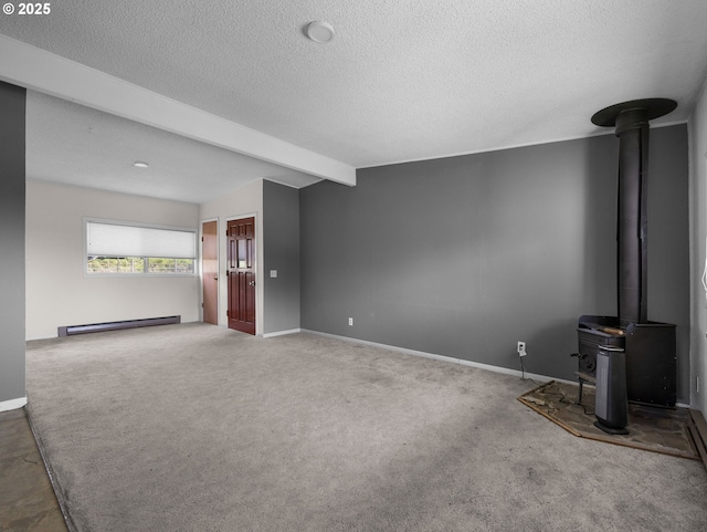 unfurnished living room featuring a baseboard radiator, a wood stove, beamed ceiling, a textured ceiling, and carpet