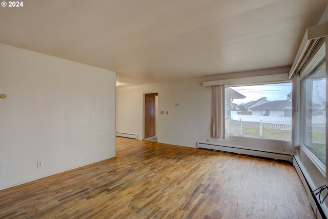 unfurnished room with light hardwood / wood-style floors and baseboard heating