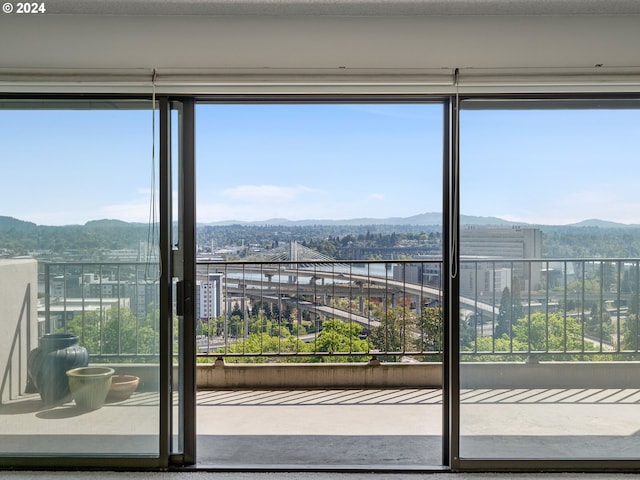 doorway featuring a healthy amount of sunlight, a mountain view, and a city view