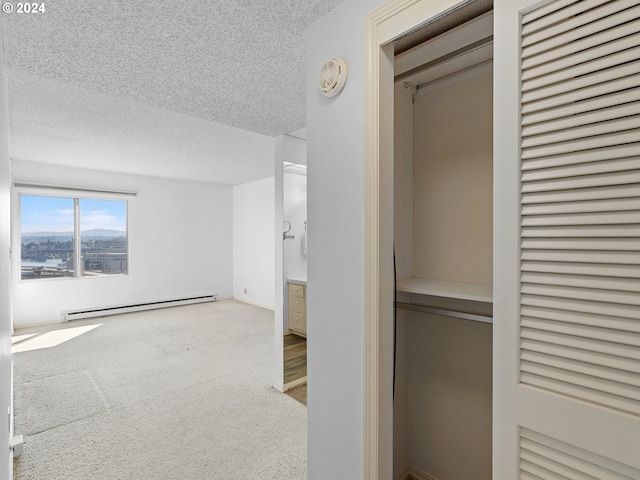 unfurnished bedroom with carpet floors, a baseboard radiator, and a textured ceiling