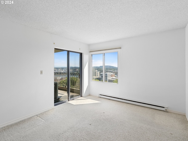 carpeted empty room with a textured ceiling, a baseboard radiator, and baseboards